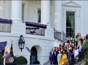Jennifer Grove, NSVRC COO, stands on White House steps as President Biden offers remarks for the 30th Anniversary of VAWA
